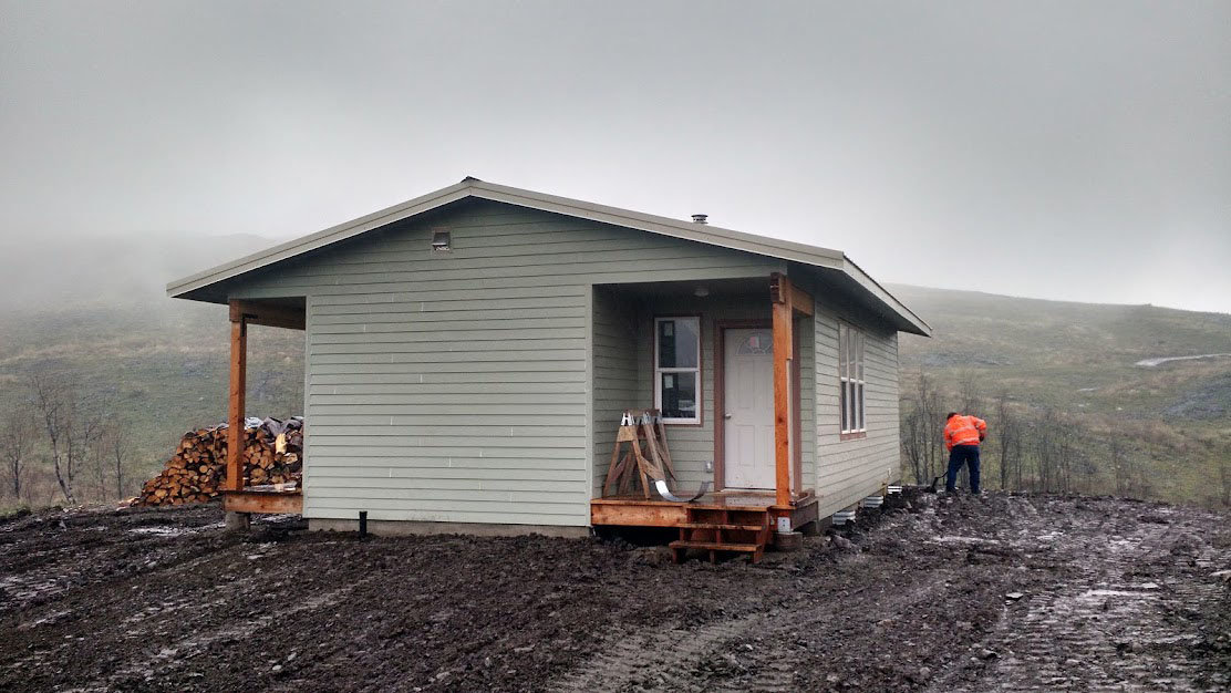 A volunteer from Restoration Hope Northwest is pictured outside of a newly constructed home in Okanogan County.